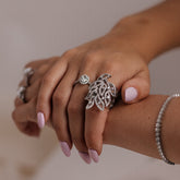 Close-up of a hand wearing multiple 18k gold rings